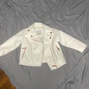 Toddler cream biker jacket with rose gold zippers.